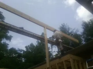 Carpenter setting a ridge beam over a new addition frame — Ice Dam Removal by Roofing Brothers in Walled Lake