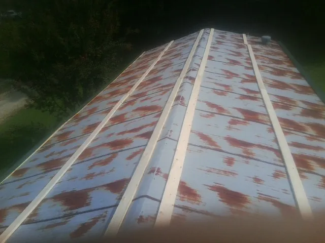 Rusted metal roof panels with new wood purlins before replacement — Storm Damage Roof Repair in Walled Lake by Roofing Brothers