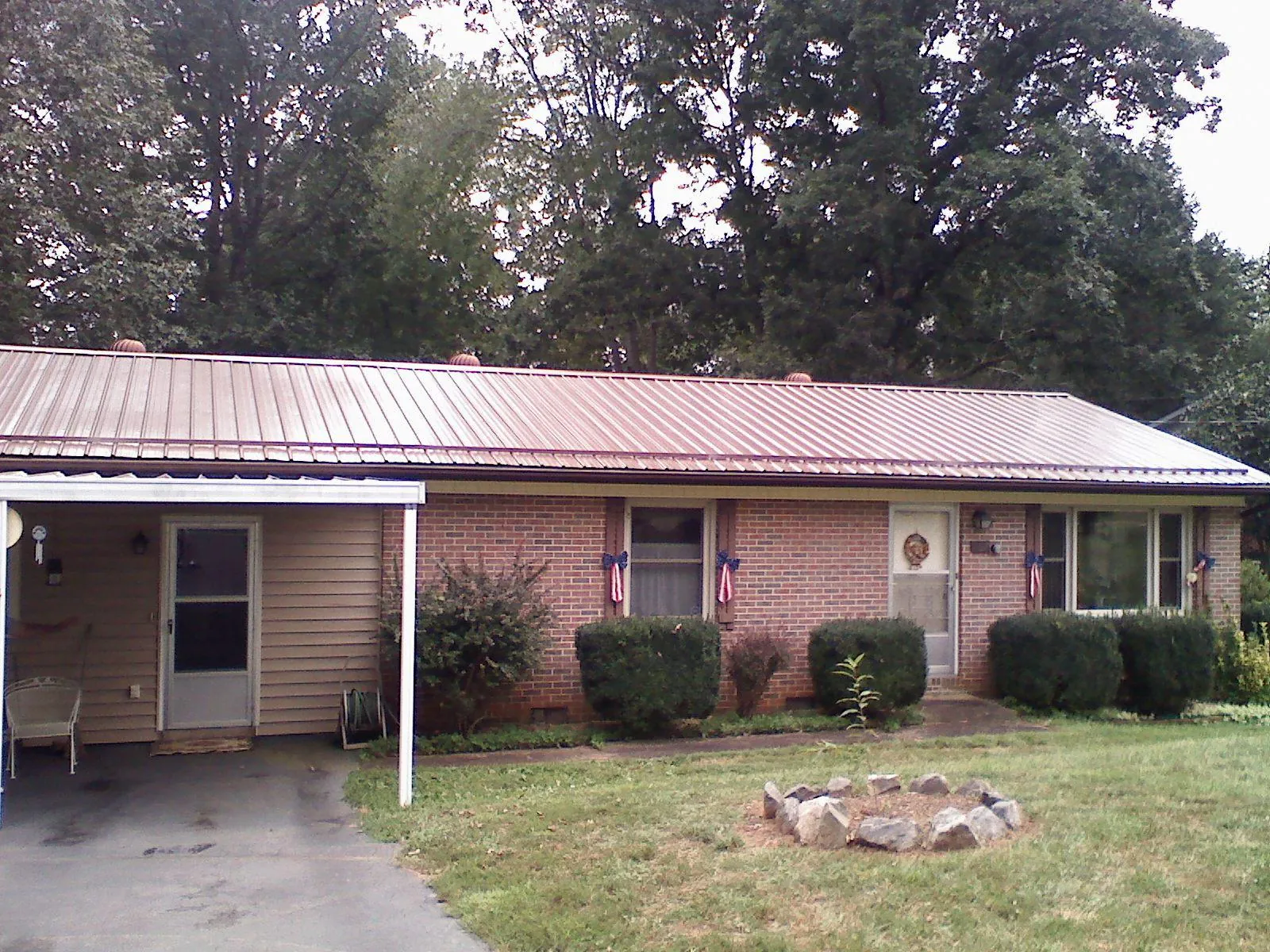 Bronze metal roof and carport on a brick ranch home — Roof Repair work by our crew in Walled Lake